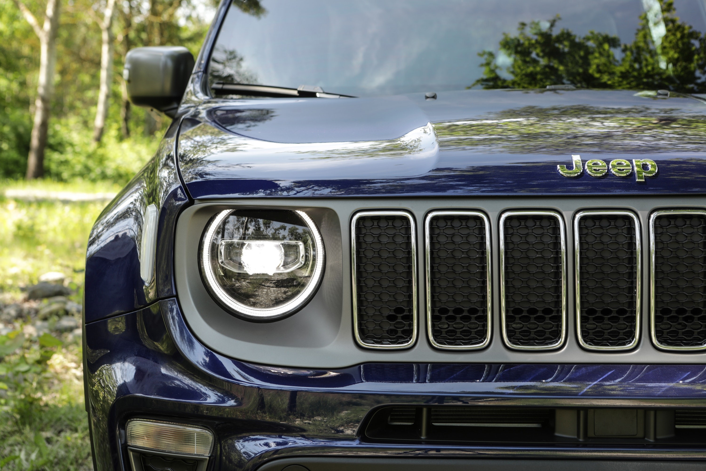 Blue Jeep Renegade headlights and badge close up